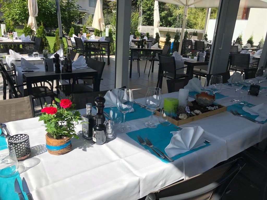 Die Gartenwirtschaft mit weiss eingedeckten Tischen und Geranien